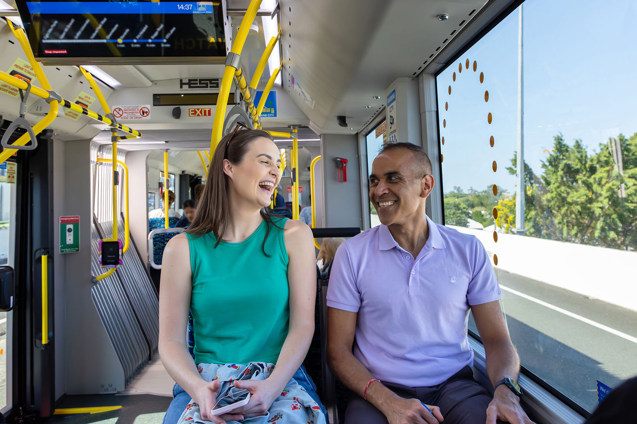 Two Metro passengers smiling at each other in a Metro vehicle