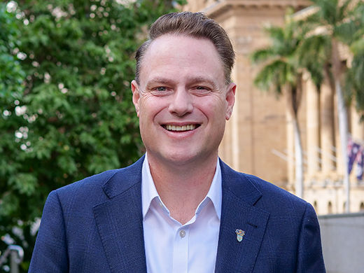 Lord Mayor Adrian Schrinner's headshot in June 2026 with City Hall and trees in the background.