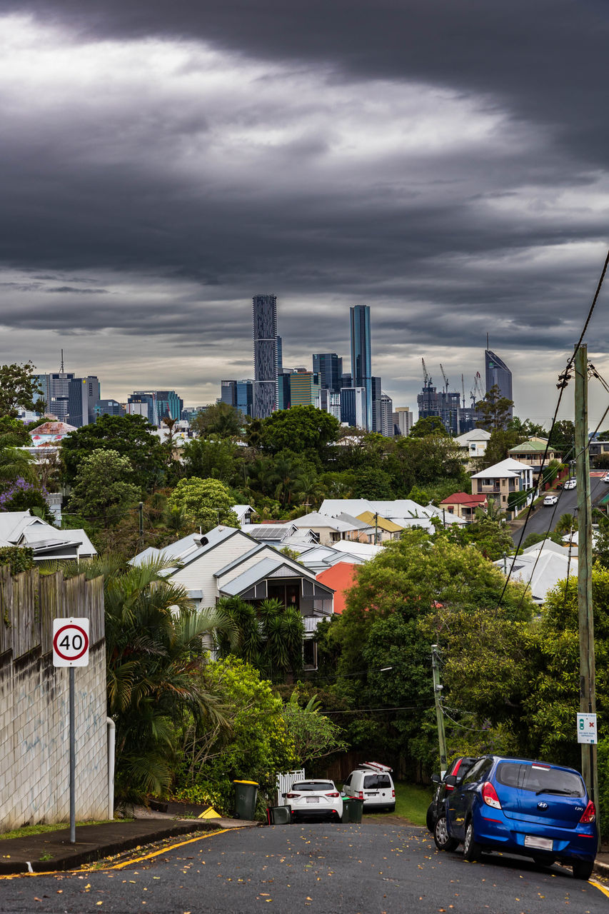 Dark grey storm clouds over the Brisbane City skyline viewed from the top of a Paddington street.