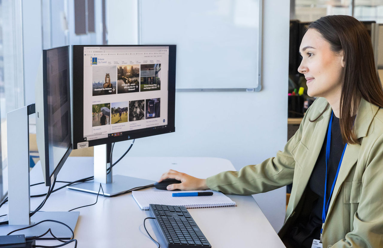A young female professional in an office environment working at a computer.