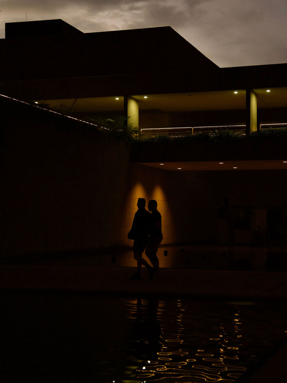 ord Mayor's Photographic Awards 2026 - Social Media Category Winner - Alex Hardings - When the fountains sleep. Two people in silhouette under lights outside the Queensland Art Gallery.