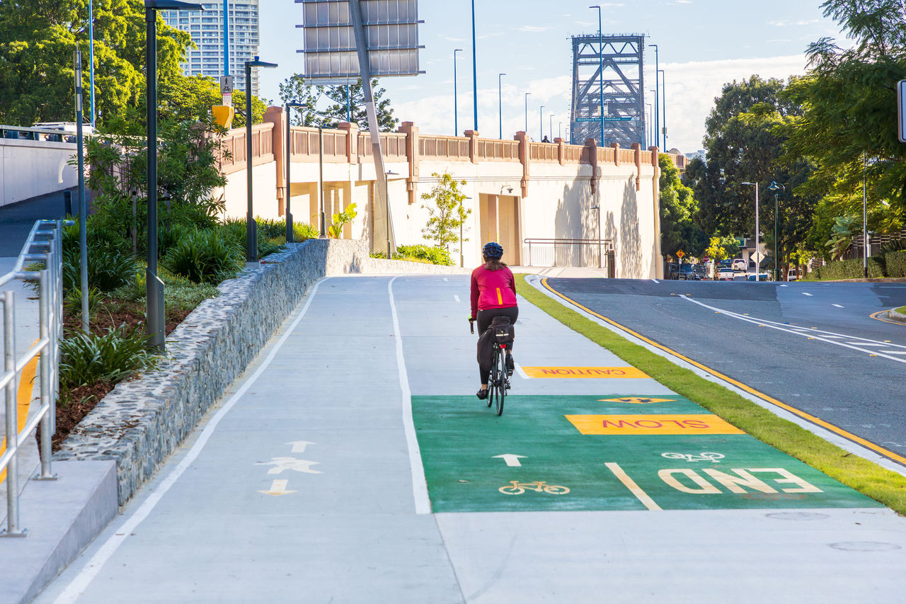 Female rider using a Brisbane bikeway with on-path markings near Story Bridge, Kangaroo Point.