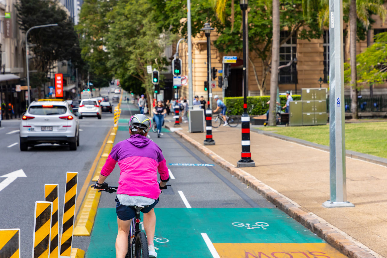 Three people riding their bikes along a bikeway path.